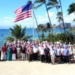 A group of people posing in front of an american flag.