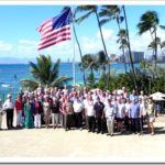 A group of people posing in front of an american flag.