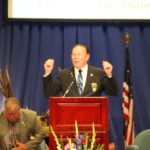 A man giving a speech at an Elks convention podium.