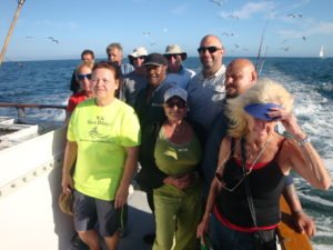 A group of people standing on the side of a boat.