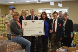 A group of people holding up a large check.