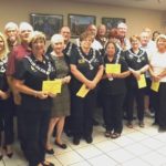 A group of people standing in front of wall with yellow papers.