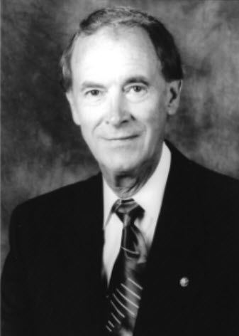 A black and white photo of an older man in a suit.