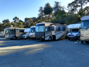 A group of recreational vehicles parked in a lot.