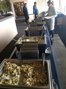 A line of food is being served at an event.