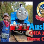 Aushay, a young boy, standing next to a blue toy train.