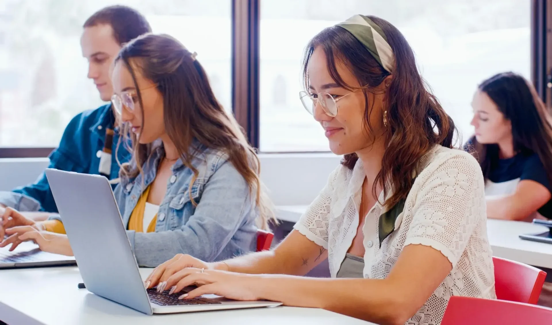 Students studying on laptops in classroom setting