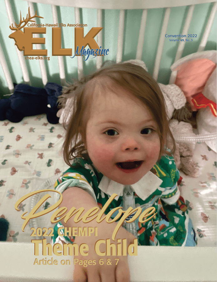 Smiling toddler reaching toward camera in crib