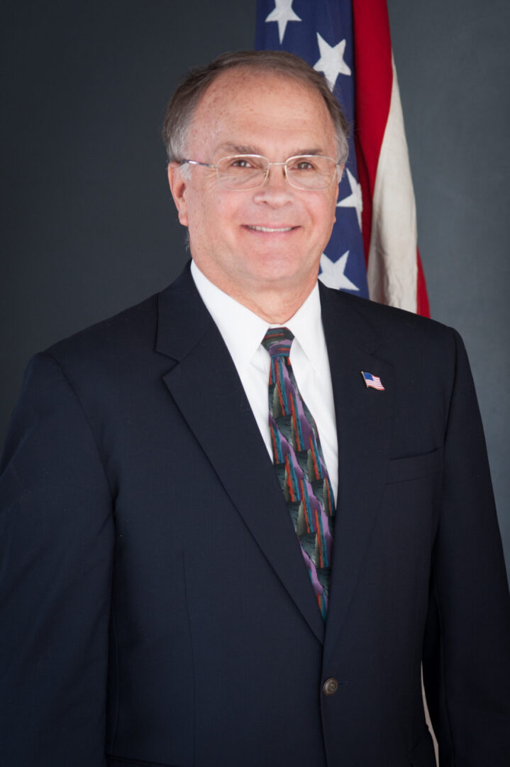 Smiling man in suit with U.S. flag