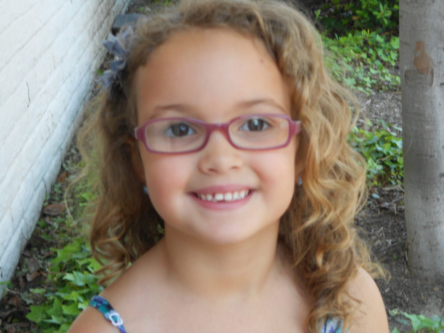 Smiling young girl wearing glasses outdoors