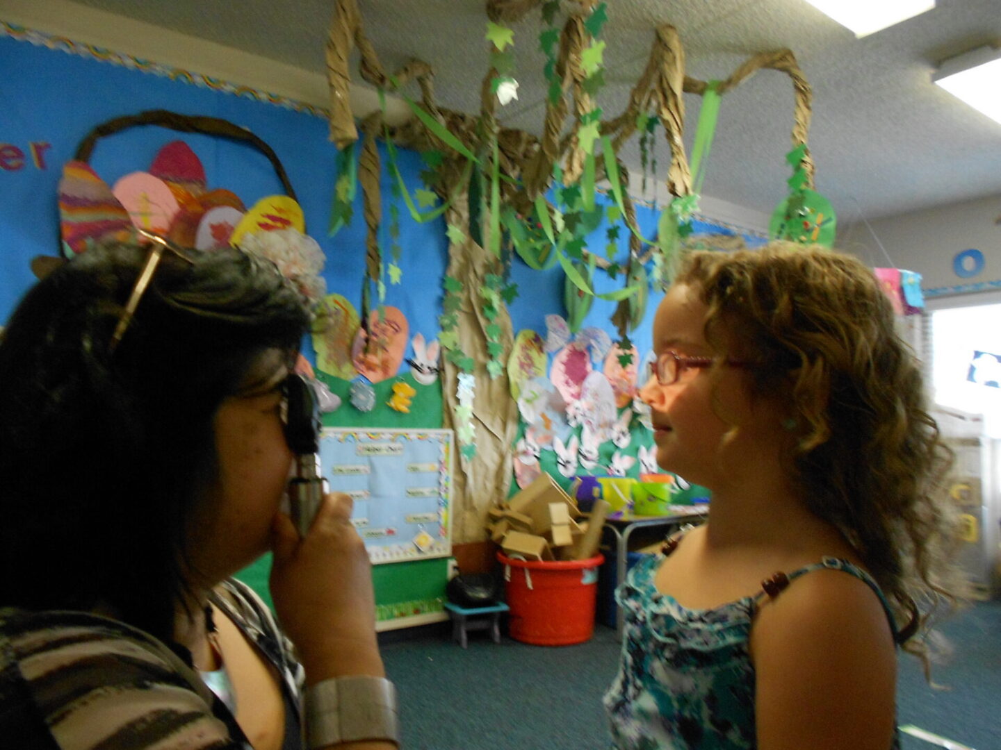 Woman and girl talking in decorated classroom
