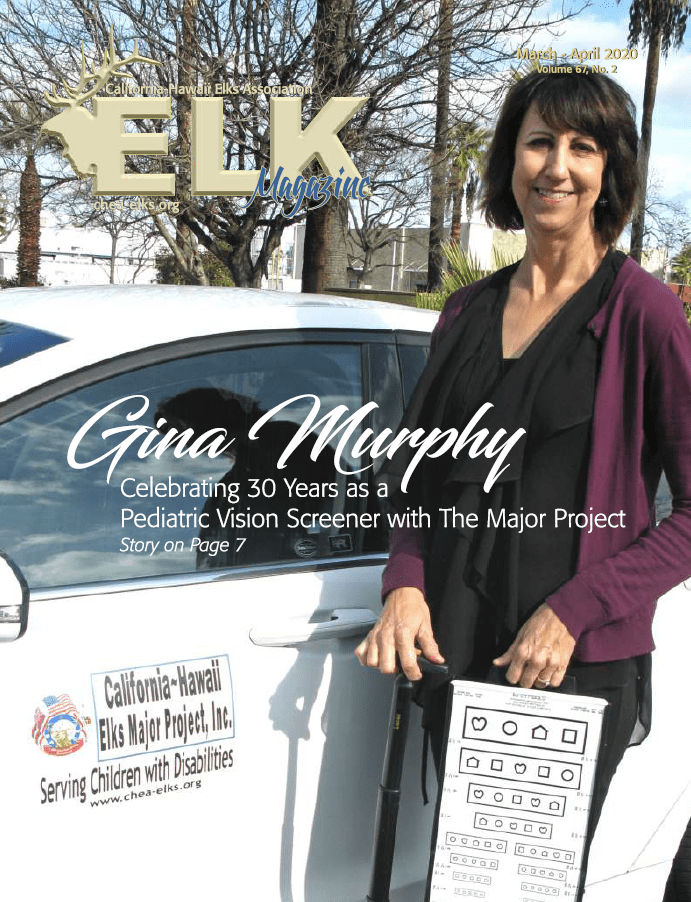 Woman standing by car holding eye chart