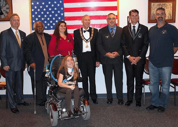 Group of people with wheelchair before American flag