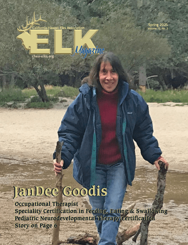 Person smiling on beach holding two sticks