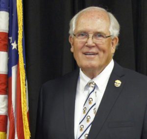 Older man in suit by American flag