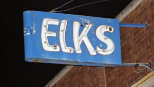 Blue ELKS neon sign on brick building