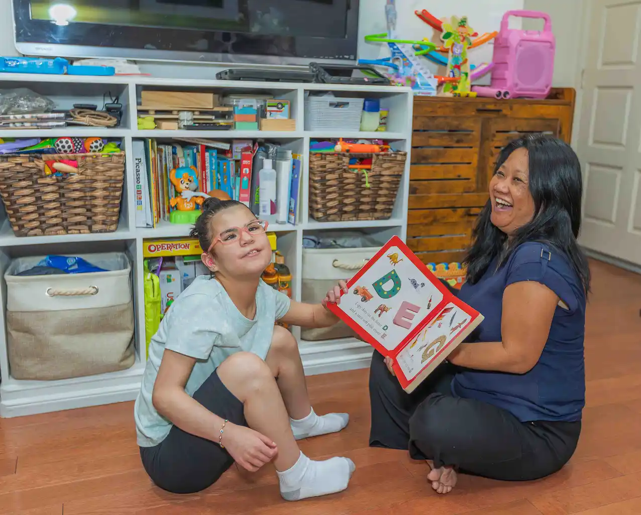 Woman and girl reading alphabet book